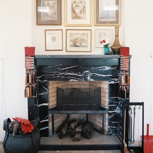 Black marble fireplace under a wall art display