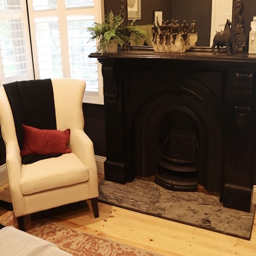 Black stone arched fireplace mantel in bedroom