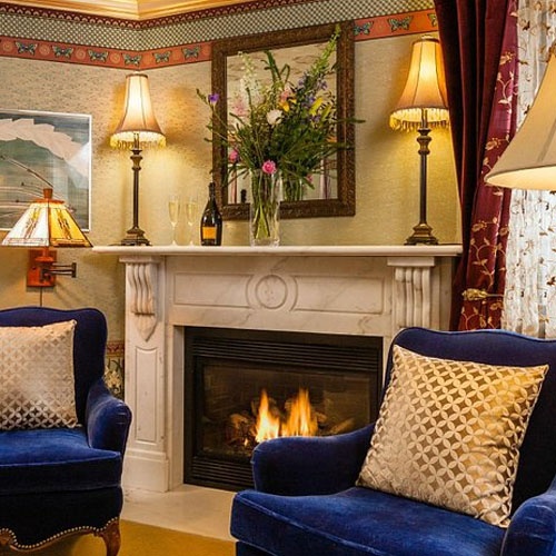 Traditional white marble fireplace mantel in village inn guestroom