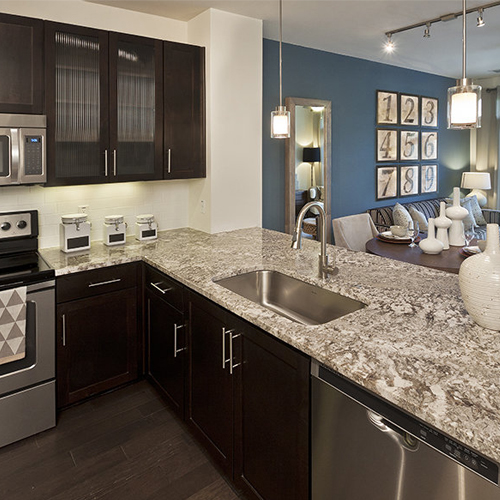 multicolor granite kitchen countertop and cherry stain wooden cabinet