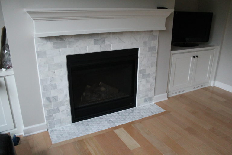 carrara marble tile and mosatic fireplace surround