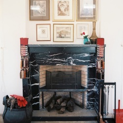 Black marble fireplace under a wall art display