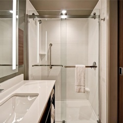 Frameless bypass glass shower door in Hilton Garden Inn Bathroom