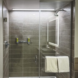 Inline hinged swing glass shower door in element hotel