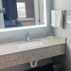 Pink granite bathroom vanity top with backspashes and front apron for Travelodge motel