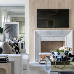 The fireplace here is cut from a slab of marble with soft gray veining