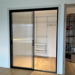 walk in closet room with sliding fluted glass door